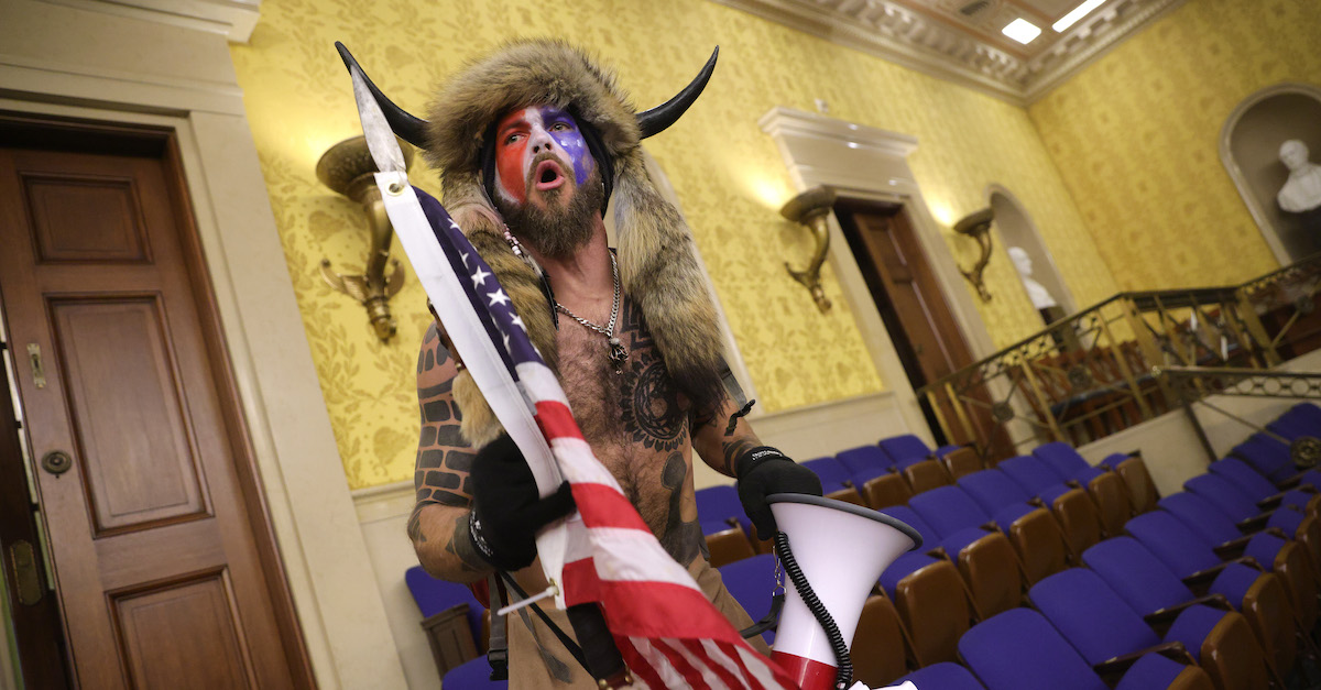 WASHINGTON, DC - JANUARY 06: A protester screams "Freedom" inside the Senate chamber after the U.S. Capitol was breached by a mob during a joint session of Congress on January 06, 2021 in Washington, DC. Congress held a joint session today to ratify President-elect Joe Biden's 306-232 Electoral College win over President Donald Trump. A group of Republican senators said they would reject the Electoral College votes of several states unless Congress appointed a commission to audit the election results. Pro-Trump protesters entered the U.S. Capitol building during demonstrations in the nation's capital. (Photo by Win McNamee/Getty Images)