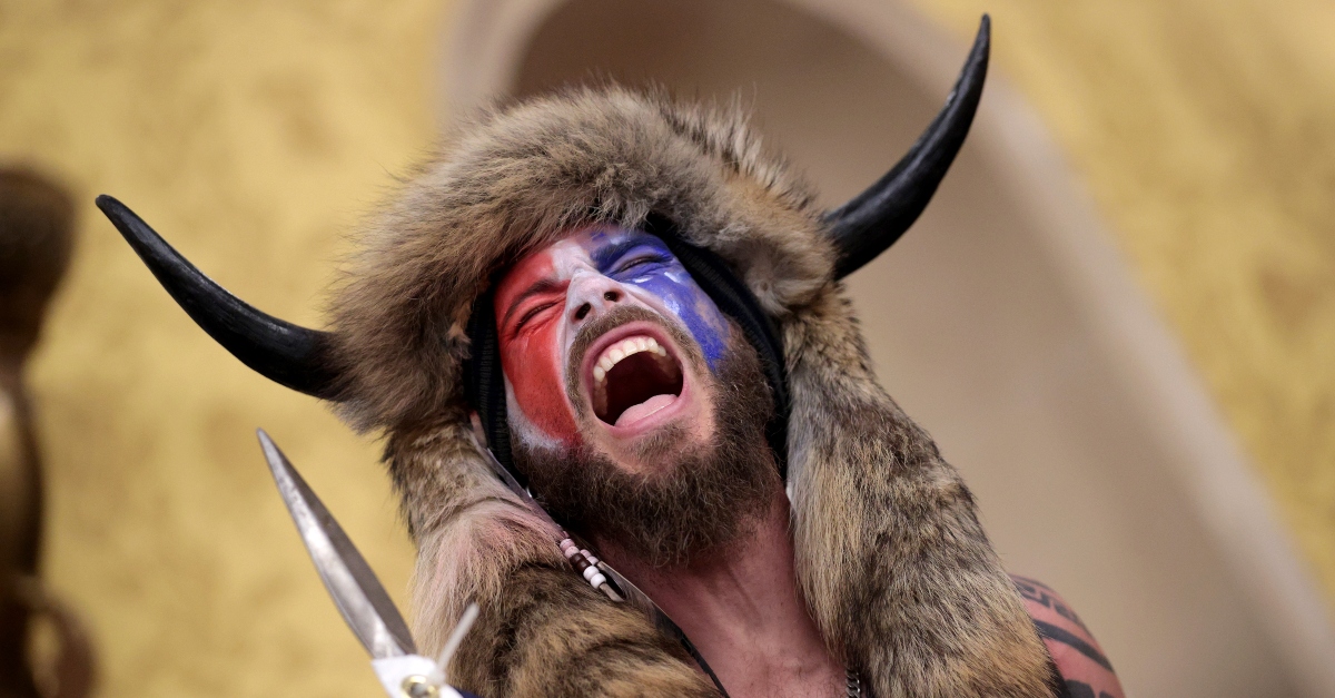 WASHINGTON, DC - JANUARY 06: A protester screams "Freedom" inside the Senate chamber after the U.S. Capitol was breached by a mob during a joint session of Congress on January 06, 2021 in Washington, DC. Congress held a joint session today to ratify President-elect Joe Biden's 306-232 Electoral College win over President Donald Trump. A group of Republican senators said they would reject the Electoral College votes of several states unless Congress appointed a commission to audit the election results. Pro-Trump protesters entered the U.S. Capitol building during demonstrations in the nation's capital. (Photo by Win McNamee/Getty Images)