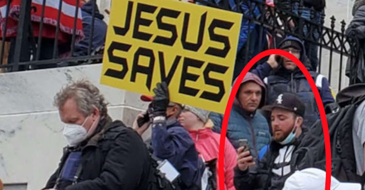 Richard Michetti is seen appearing to look at his phone outside the Capitol on Jan. 6