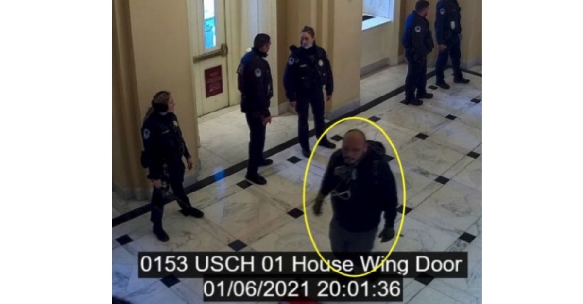 Moises Romero walking by law enforcement in the Capitol building