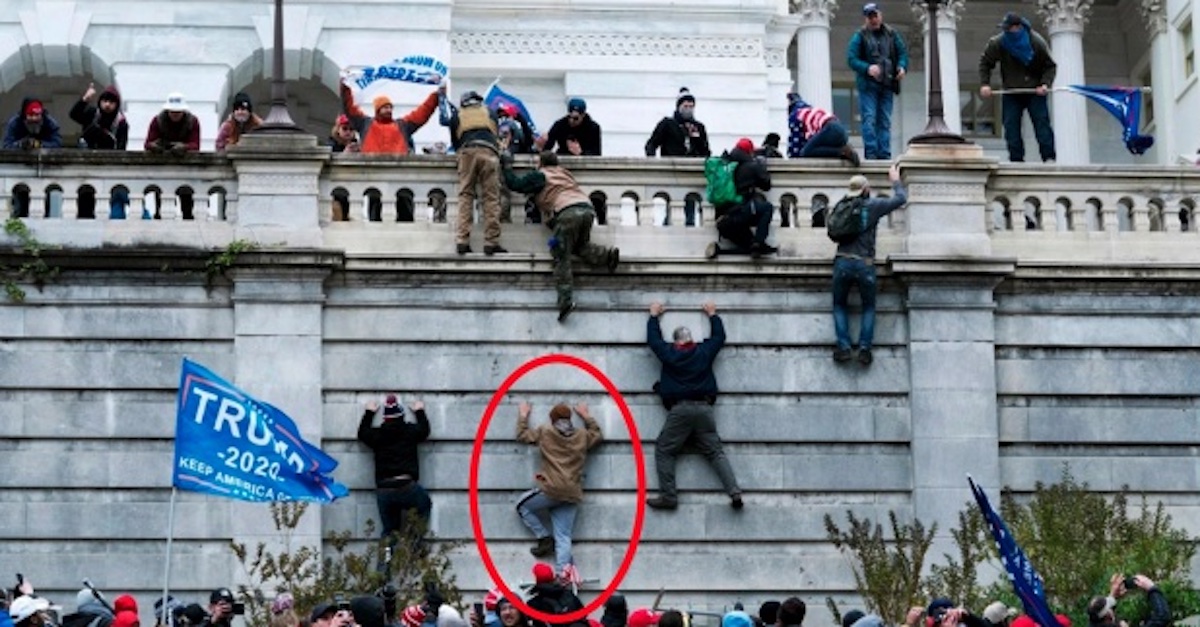 Jordan Stotts is seen scaling a wall in an attempt to get into the U.S. Capitol building on Jan. 6, 2021 