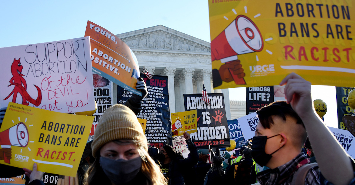 Protesters, demonstrators and activists gather in front of the U.S. Supreme Court on Dec. 1, 2021, as the justices hear arguments in Dobbs v. Jackson Women's Health, a case about a Mississippi law that bans most abortions after 15 weeks. (Photo by Olivier Douliery/AFP via Getty Images.)