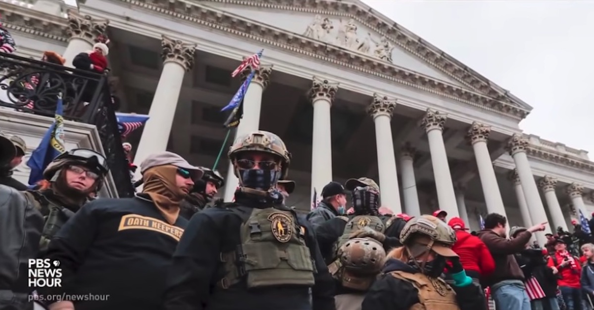 People wearing clothing with "Oath Keepers" labels are seen outside the Capitol on Jan. 6.