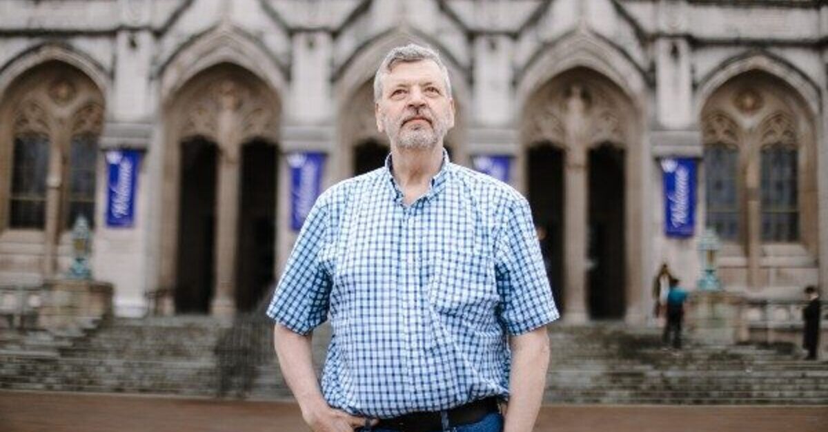 Professor Stuart Reges stands in front of a UW building and stairs