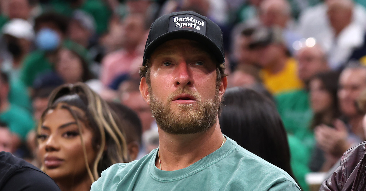 David Portnoy, founder of Barstool Sports, is seen wearing a black baseball cap that says "Barstool Sports" and a green Celtics t-shirt as he watches the Celtics play.