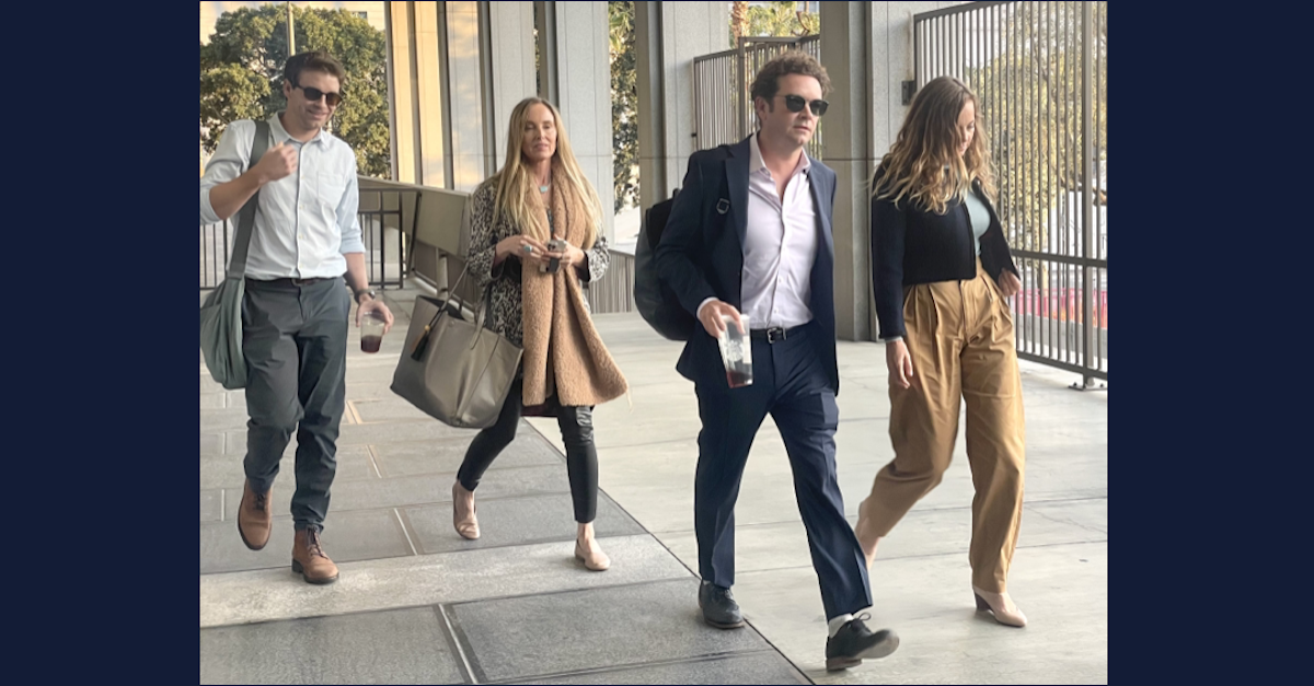 Four people walking out of a courthouse