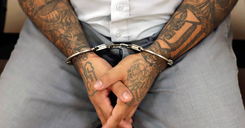 A handcuffed Mara Salvatrucha gang member awaits the start of a trial at the Isidro Menendez Justice Center in San Salvador, El Salvador, on Thursday, October 10, 2019. El Salvador on Tuesday launched a mass trial of over 400 suspected gang members. including alleged leaders of the feared transnational criminal group Mara Salvatrucha or MS-13. (AP Photo/Salvador Melendez)