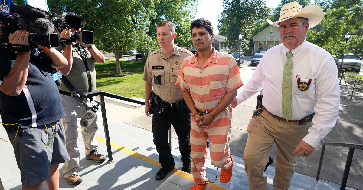 Francisco Oropeza, center, is escorted to the San Jacinto County courthouse by San Jacinto County Sheriff Greg Capers, right, for a hearing Thursday, May 18, 2023, in Coldspring, Texas. Oropeza is suspected of killing five people, including a 9-year-old boy, after neighbors asked him to stop firing off rounds in his yard. (AP Photo/David J. Phillip)