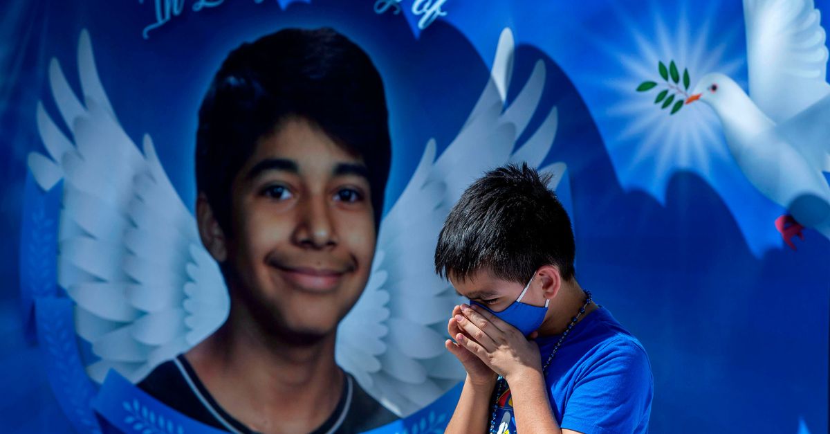 Eric Henry, 9, of Moreno Valley, prays during a 2020 memorial in the parking lot of Landmark Middle School to commemorate the death of Diego Stolz, who was fatally assaulted in September 2019 by two other students in Moreno Valley, Calif. a Southern California school district has agreed to pay $27 million to settle a lawsuit by the family of Diego Stolz, an 8th grade boy who died after being assaulted by two other students at a middle school four years ago. The settlement with the Moreno Valley Unified School District was announced Wednesday, Sept. 13, 2023. (Terry Pierson/The Orange County Register via AP)