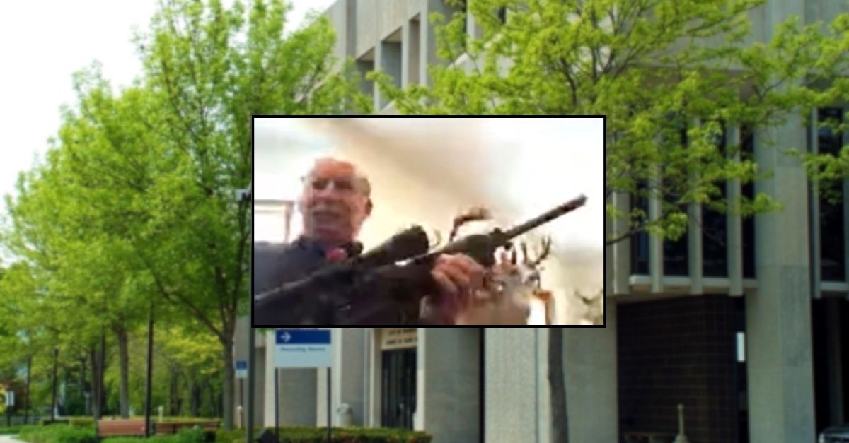 Background: Grand Traverse County Governmental Center (Grand Traverse County). Inset: FILE - In this image from a Zoom meeting provided by the Grand Traverse, Mich., County Board of Commissioners, Grand Traverse County Commissioner Ron Clous holds a rifle at his home during a county commissioners meeting, Jan. 20, 2021, in Michigan (Grand Traverse County Board of Commissioners via AP, File).