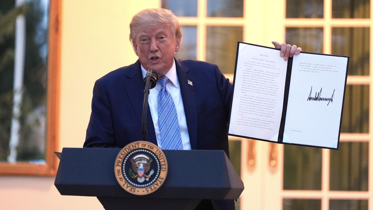 Donald Trump shows a signed order.